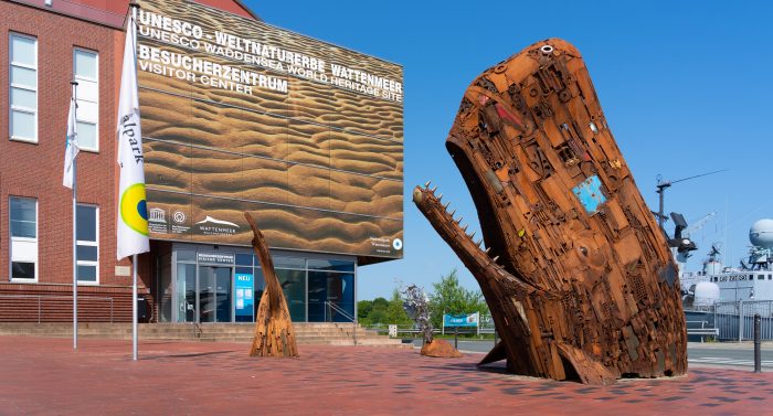 Eingang zum Wattenmeer-Besucherzentrum Wilhelmshaven mit Pottwal-Skulpturen auf dem Vorplatz